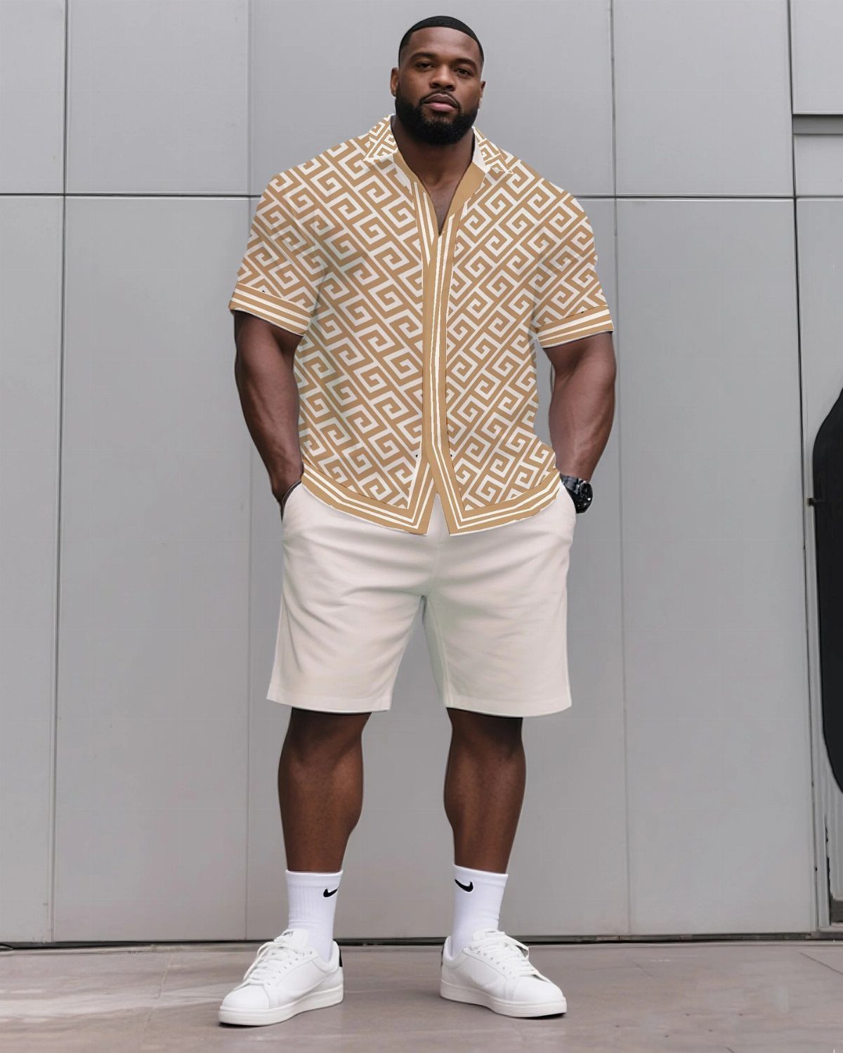 A muscular man posing in a patterned short-sleeved shirt and white shorts.