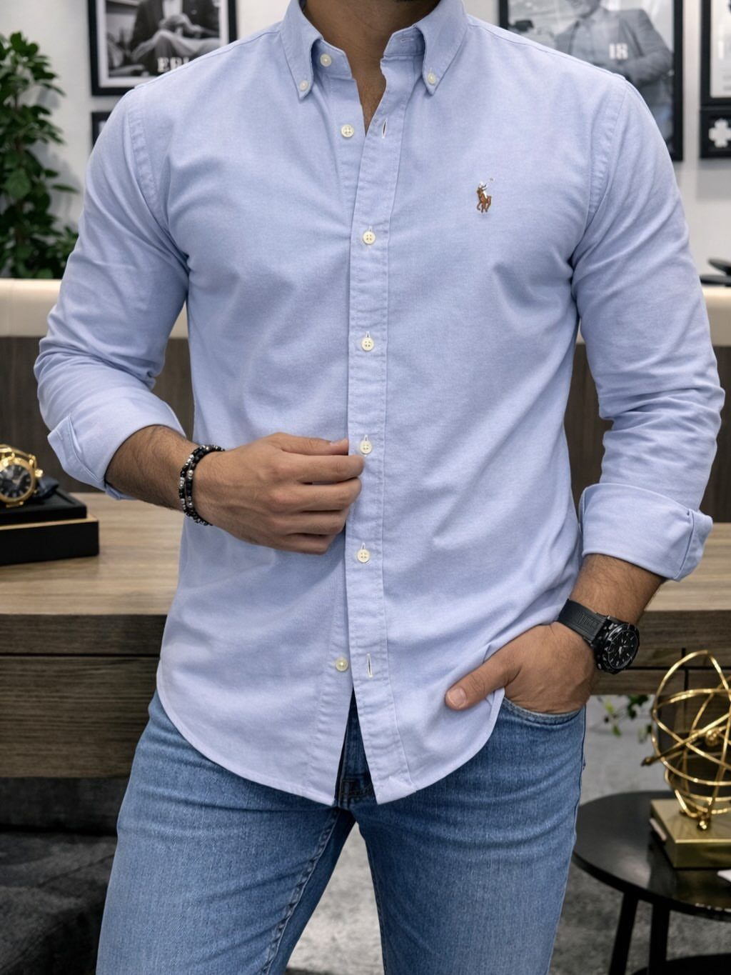 Man wearing a light blue button-down shirt and blue denim jeans.