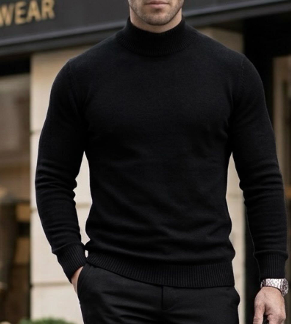 Man wearing a black turtleneck sweater and black trousers standing outdoors.