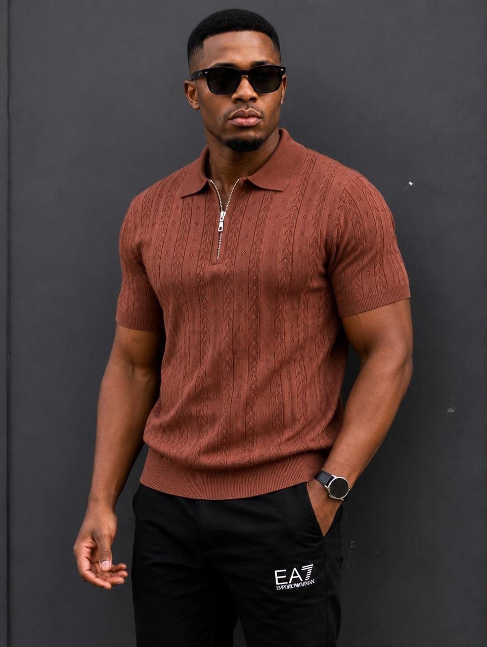Man in a brown textured polo shirt with a zipper and black sunglasses.