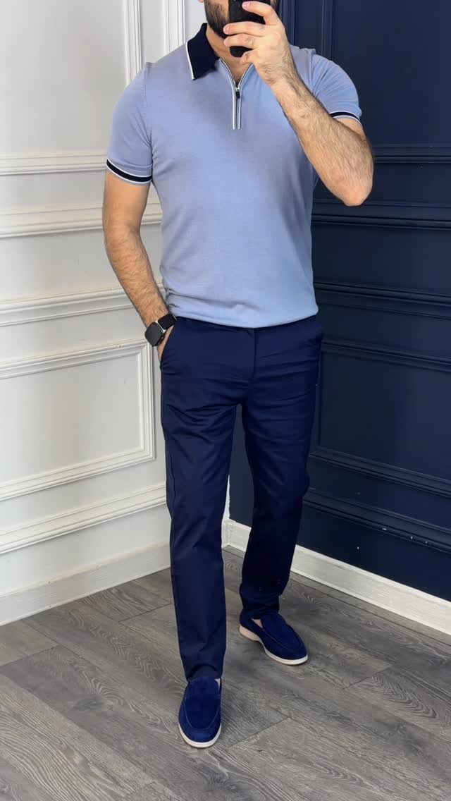Man wearing a light blue polo shirt with navy trim, navy trousers, and blue slip-on shoes.