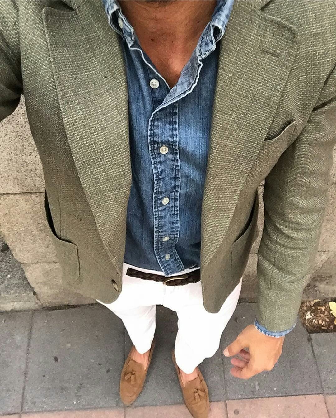 Man wearing an olive green unstructured blazer, denim shirt, white pants, and tan loafers.